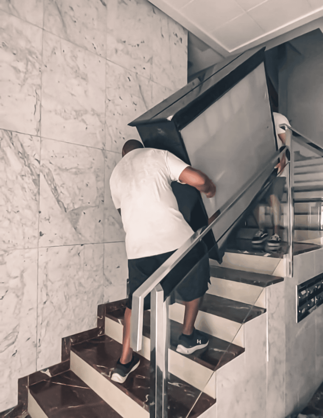Two men carrying furniture
